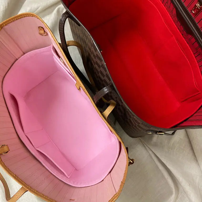 Pink and red felt bag organizers inside two open Louis Vuitton Neverfull totes.
